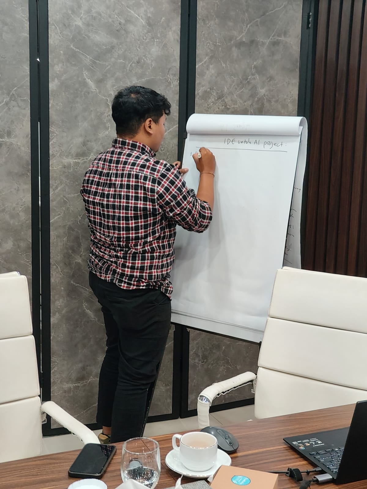 Peserta menuliskan daftar ide proyek AI di papan tulis kertas